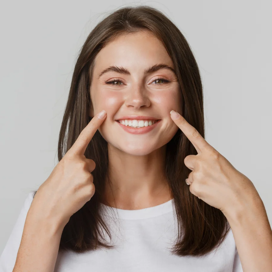 mujer feliz mostrando su diseño de sonrisa hecha en Colombia por Beaming Dental Clinic